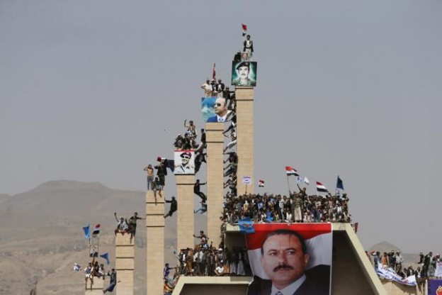Supporters of Yemen's former President Ali Abdullah Saleh climb pillars of the Unknown Soldier Monument during a rally marking one year of Saudi-led air strikes in Yemen's capital Sanaa March 26, 2016. REUTERS/Khaled Abdullah