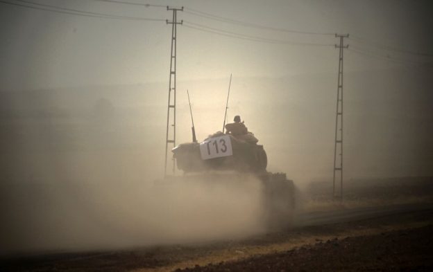This picture taken on August 24, 2016 shows a Turkish army tank driving towards Syria  in the Turkish-Syrian border city of Karkamis, in the southern region of Gaziantep.
Turkey's army backed by international coalition air strikes launched an operation involving fighter jets and elite ground troops to drive Islamic State jihadists out of a key Syrian border town. / AFP PHOTO / BULENT KILIC